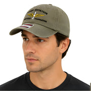 Green Army Aviation Heritage Foundation Dad Hat - SearchPify - Man wearing a green cap with embroidered text and logo on a white background