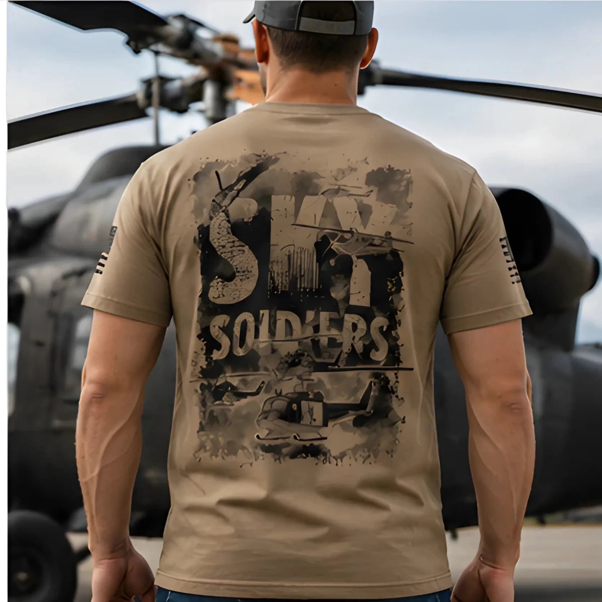 Sky Soldiers Short-Sleeve T-Shirt - SearchPify - Person wearing a tan t-shirt with 'SHARK SOLDIERS' graphic design in front of a helicopter.