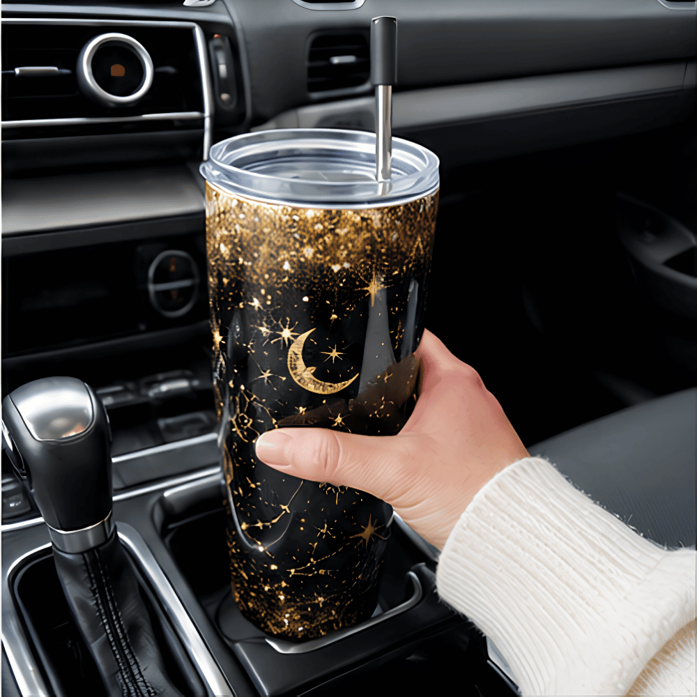 20 oz Constellation Tumbler - SearchPify - Elizabeth’s Jewelry & Creations Hand holding a glittery tumbler with star and moon design inside a car.