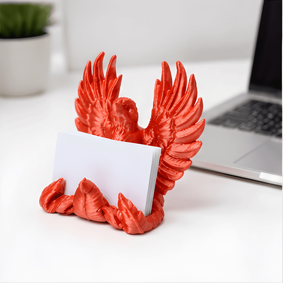 3D-Printed Business Card Holder - SearchPify - Red eagle-shaped card holder on a desk with a laptop and plant in the background