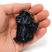3D-Printed Dragon Keychain Storage Container - SearchPify - Black keychain shaped like a character held in a hand against a white background