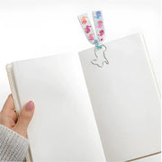 Animals Paperclip Bookmark - White Bunny - SearchPify - Hand holding a notebook with a decorative bookmark featuring cartoon characters.