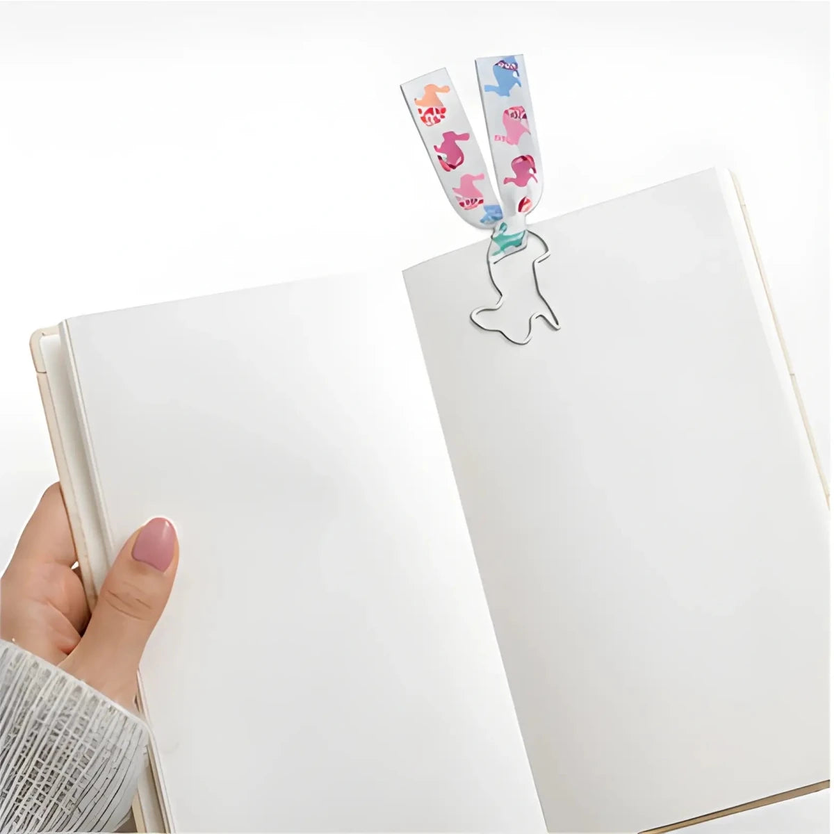 Animals Paperclip Bookmark - White Bunny - SearchPify - Hand holding a notebook with a decorative bookmark featuring cartoon characters.
