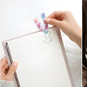 Animals Paperclip Bookmark - White Bunny - SearchPify - Hand holding a notebook with decorative paper clips featuring cartoon characters.