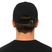 Person wearing a black cap with a gold buckle on a white background